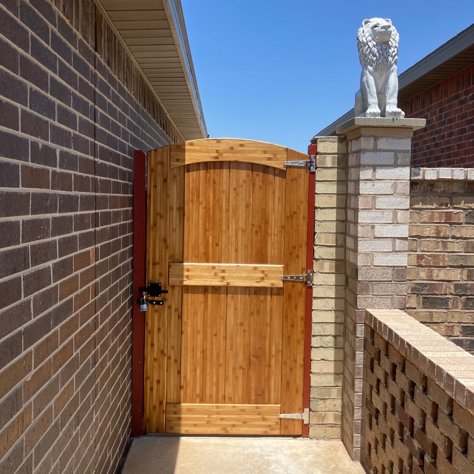 Stained arched bamboo gate between brick walls