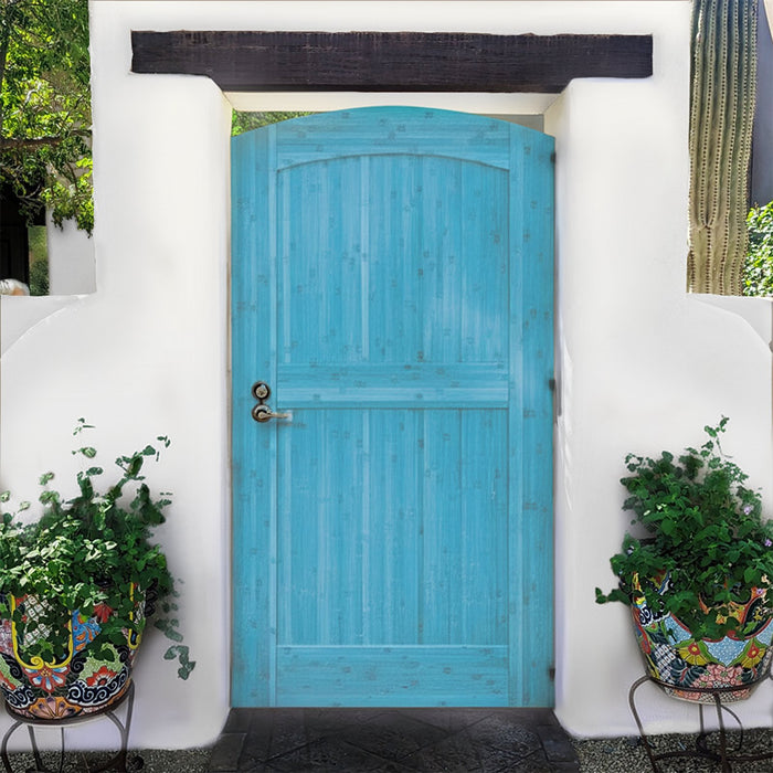 Turquoise-painted arched bamboo gate in an adobe wall