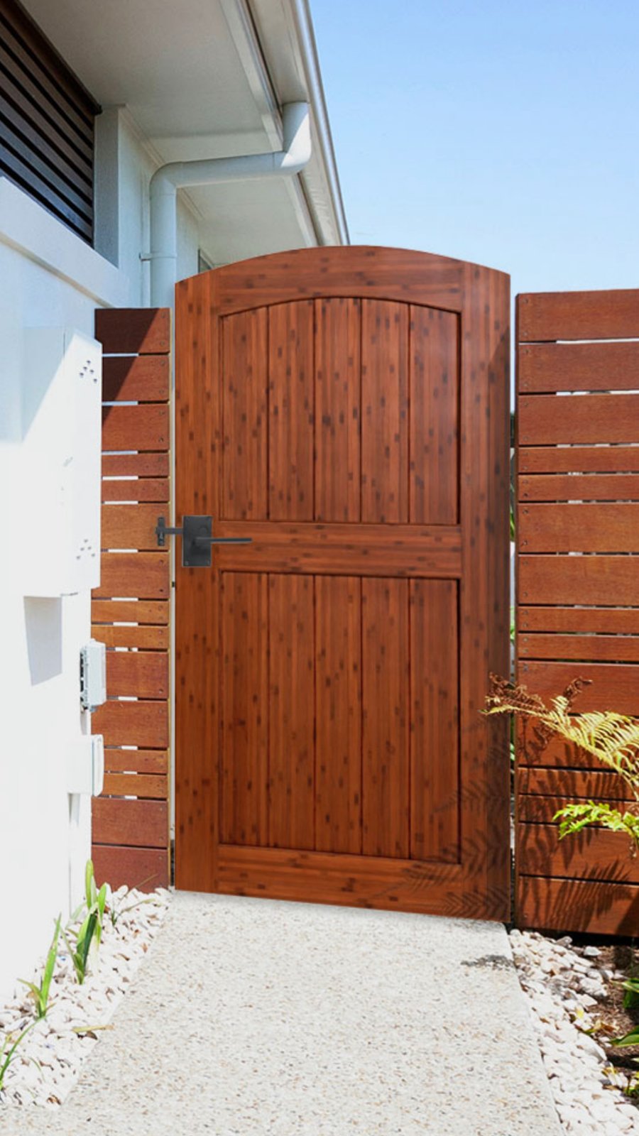 Umber-stained arched bamboo gate at a modern side entry